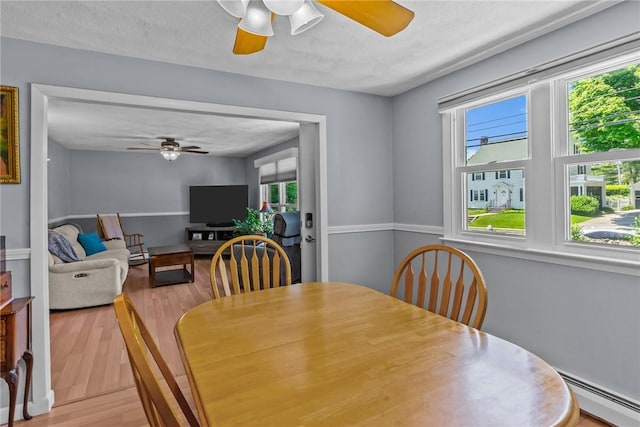 21 High Service Ave, North Providence, RI 02911 - dining space featuring ceiling fan, a baseboard radiator, and plenty of natural light