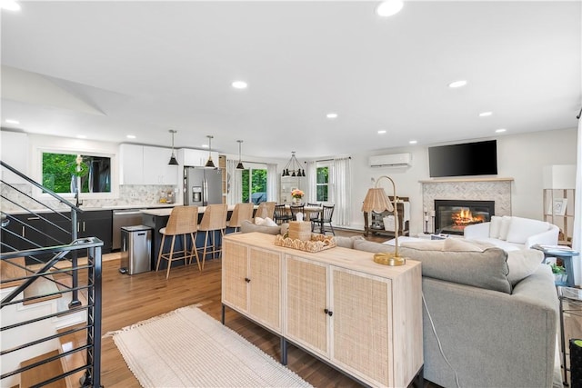 50 Maureen Dr, Smithfield, RI 02917 - living area featuring a wall mounted AC, recessed lighting, plenty of natural light, wood finished floors, and a glass covered fireplace
