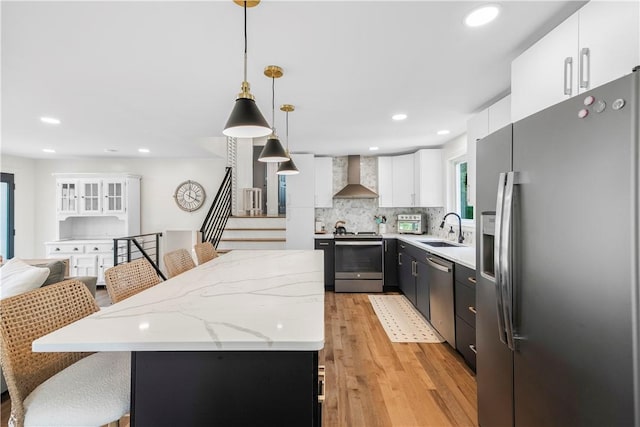 50 Maureen Dr, Smithfield, RI 02917 - kitchen with appliances with stainless steel finishes, wall chimney range hood, a sink, a kitchen island, and light wood-style flooring