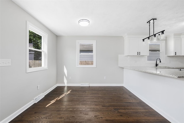 21 Victor Emanuel Ave, Providence, RI 02904 - unfurnished dining area featuring dark wood-style flooring, a sink, and baseboards
