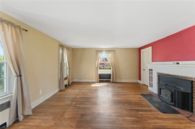 282 Seven Mile Rd, Scituate, RI 02831 - unfurnished living room featuring wood finished floors, radiator heating unit, a wood stove, and baseboards