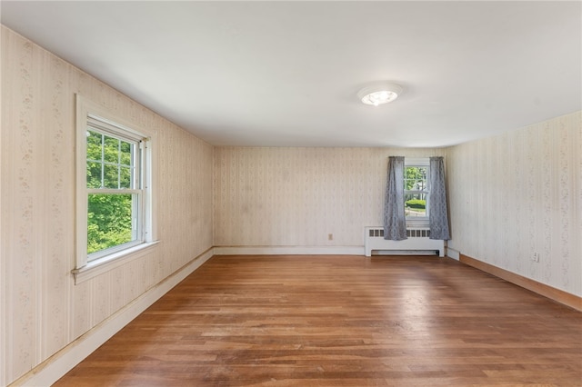 282 Seven Mile Rd, Scituate, RI 02831 - unfurnished room with radiator heating unit, wood finished floors, healthy amount of natural light, wallpapered walls, and baseboards