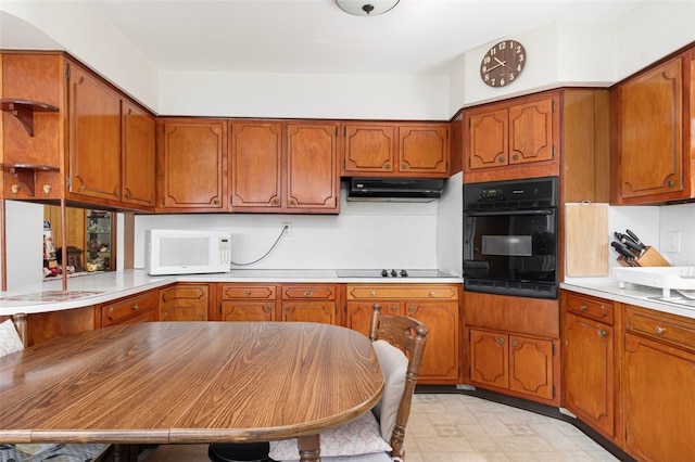 32 N Clarendon St, Cranston, RI 02910 - kitchen with black appliances, under cabinet range hood, brown cabinetry, and light countertops