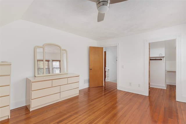 32 N Clarendon St, Cranston, RI 02910 - unfurnished bedroom with light wood finished floors, baseboards, a walk in closet, a ceiling fan, and lofted ceiling