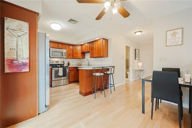 2970 Mendon Rd Unit 53, Cumberland, RI 02864 - kitchen featuring stainless steel appliances, a peninsula, ceiling fan, light countertops, and a breakfast bar area