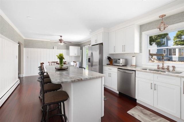6 Humes Ave, Warwick, RI 02889 - kitchen featuring appliances with stainless steel finishes, a baseboard heating unit, a breakfast bar, white cabinets, and a wainscoted wall