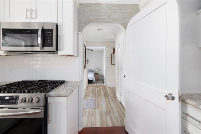 6 Humes Ave, Warwick, RI 02889 - kitchen with appliances with stainless steel finishes, white cabinetry, light wood-style flooring, light stone countertops, and ornamental molding