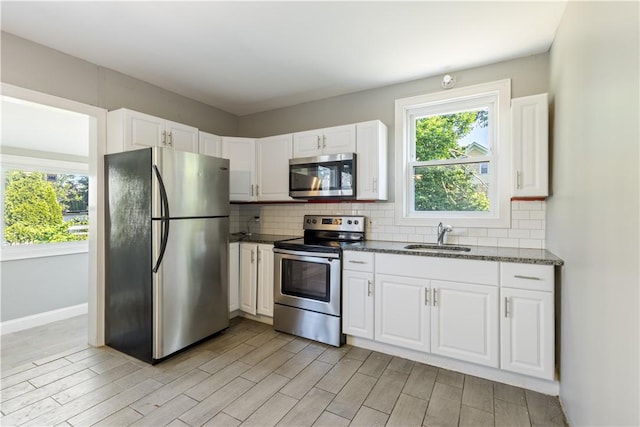 103 Henrietta St, Providence, RI 02904 - kitchen with appliances with stainless steel finishes, light wood-style floors, a sink, and white cabinetry
