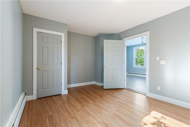 103 Henrietta St, Providence, RI 02904 - unfurnished bedroom with a baseboard radiator, light wood-style flooring, and baseboards