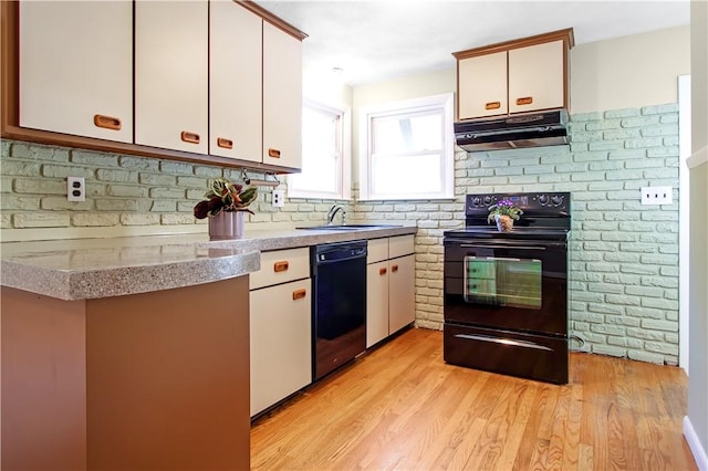 295 Chestnut St, Warwick, RI 02888 - kitchen featuring black appliances, under cabinet range hood, a sink, white cabinetry, and light wood finished floors