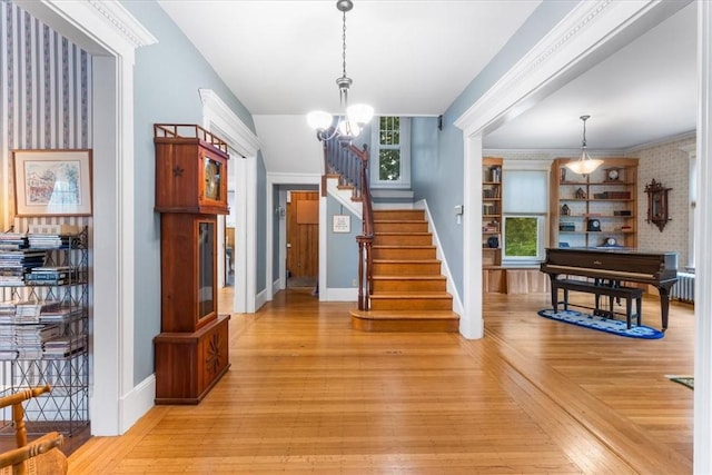 59 Woodland Rd, Woonsocket, RI 02895 - entrance foyer with stairs, a chandelier, baseboards, and light wood finished floors
