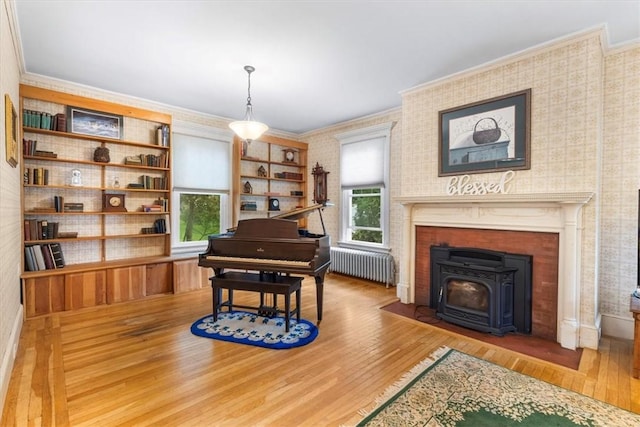 59 Woodland Rd, Woonsocket, RI 02895 - living area with radiator heating unit, wood finished floors, ornamental molding, a wood stove, and wallpapered walls