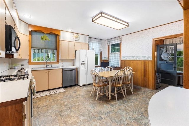 59 Woodland Rd, Woonsocket, RI 02895 - kitchen featuring stainless steel appliances, a sink, wallpapered walls, wainscoting, and light countertops