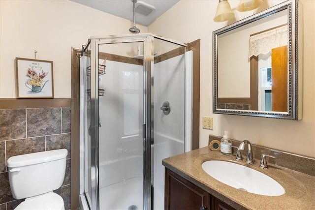 59 Woodland Rd, Woonsocket, RI 02895 - bathroom with vanity, a stall shower, toilet, and tile walls