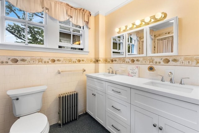 59 Woodland Rd, Woonsocket, RI 02895 - full bathroom with radiator, tile walls, double vanity, wainscoting, and toilet