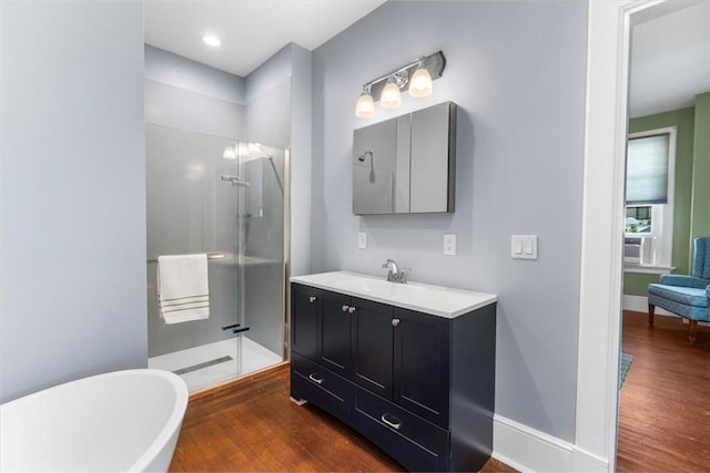 59 Woodland Rd, Woonsocket, RI 02895 - full bathroom featuring a stall shower, wood finished floors, vanity, a soaking tub, and baseboards