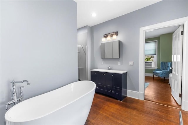59 Woodland Rd, Woonsocket, RI 02895 - bathroom featuring wood finished floors, vanity, a freestanding tub, a shower, and baseboards