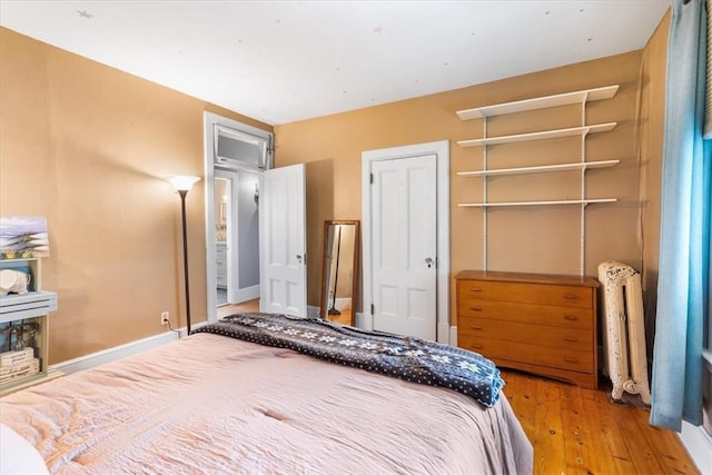 59 Woodland Rd, Woonsocket, RI 02895 - bedroom with radiator heating unit, wood-type flooring, and a closet