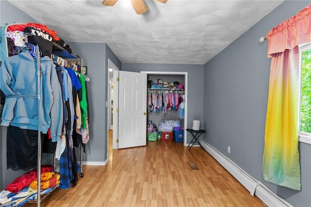 16 Spectacle Ave, Warwick, RI 02888 - unfurnished bedroom with baseboard heating, wood finished floors, baseboards, and ceiling fan