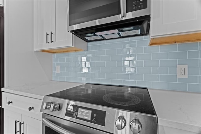18 State St Unit 3E, Bristol, RI 02809 - kitchen with stainless steel appliances, white cabinets, tasteful backsplash, and light stone counters