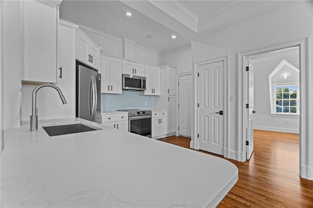 18 State St Unit 3E, Bristol, RI 02809 - kitchen with appliances with stainless steel finishes, white cabinets, dark wood-style flooring, a sink, and backsplash