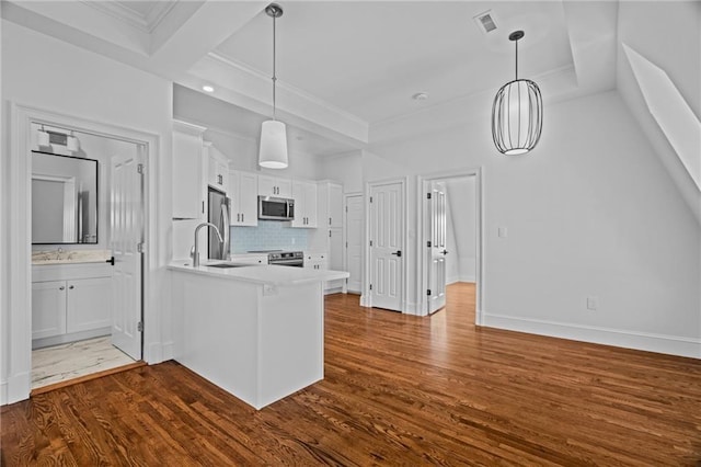 18 State St Unit 3E, Bristol, RI 02809 - kitchen featuring appliances with stainless steel finishes, a peninsula, backsplash, white cabinets, and ornamental molding