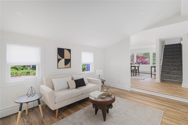 126 Weaver Hill Rd, West Greenwich, RI 02817 - living area featuring lofted ceiling, baseboard heating, wood finished floors, stairs, and baseboards