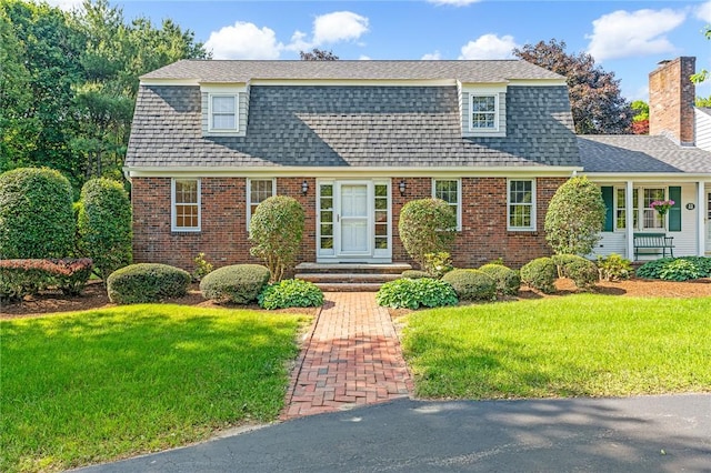 11 Crosswynds Dr, Narragansett, RI 02874 - colonial inspired home with brick siding, a front yard, a gambrel roof, and a chimney