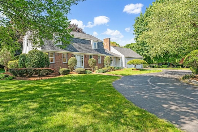 11 Crosswynds Dr, Narragansett, RI 02874 - colonial inspired home featuring a chimney, brick siding, driveway, a front yard, and a gambrel roof