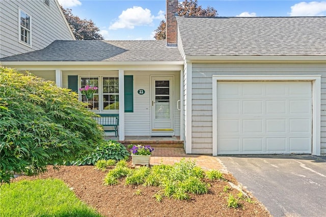 11 Crosswynds Dr, Narragansett, RI 02874 - view of front of house featuring a chimney, covered porch, roof with shingles, asphalt driveway, and a garage