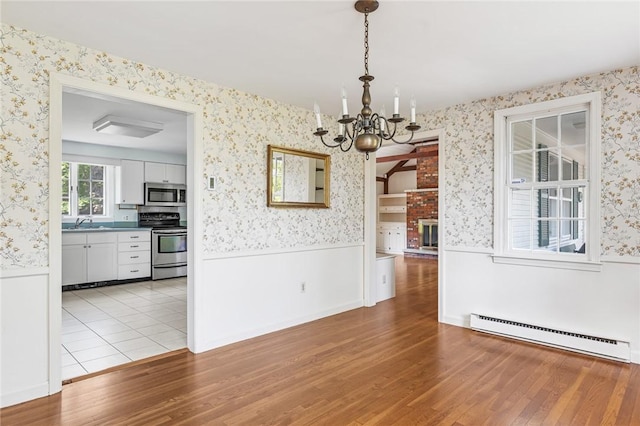 11 Crosswynds Dr, Narragansett, RI 02874 - unfurnished dining area with wallpapered walls, baseboard heating, wainscoting, a chandelier, and light wood-type flooring