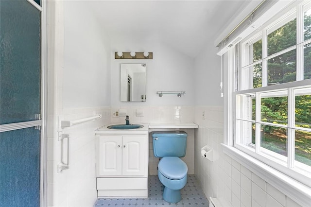 11 Crosswynds Dr, Narragansett, RI 02874 - bathroom featuring tile walls, toilet, vanity, vaulted ceiling, and a wainscoted wall