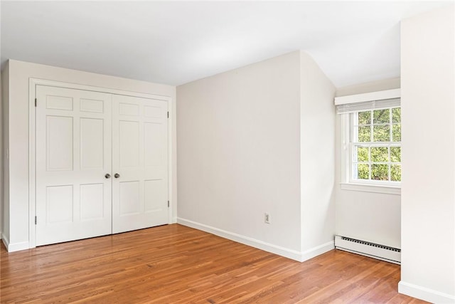 11 Crosswynds Dr, Narragansett, RI 02874 - unfurnished bedroom featuring a baseboard heating unit, light wood-style floors, baseboards, and a closet