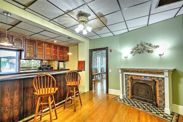 2970 Mendon Rd Unit 160, Cumberland, RI 02864 - kitchen with dark countertops, light wood-style flooring, a tiled fireplace, ceiling fan, and plenty of natural light