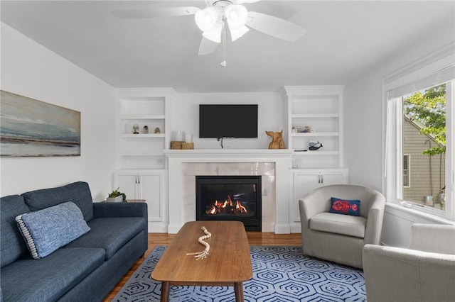 19 Woodsia Rd, Narragansett, RI 02874 - living room with built in shelves, a tile fireplace, wood finished floors, and a ceiling fan