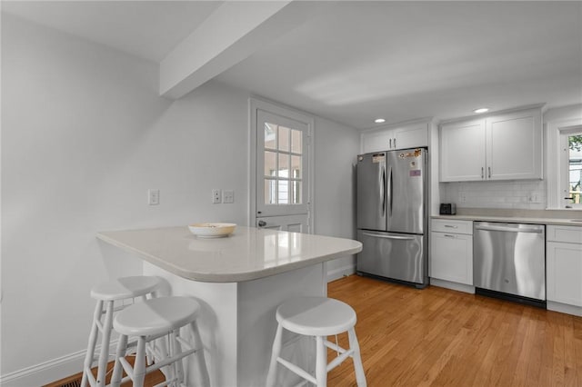 19 Woodsia Rd, Narragansett, RI 02874 - kitchen featuring stainless steel appliances, a kitchen breakfast bar, a peninsula, light countertops, and white cabinets