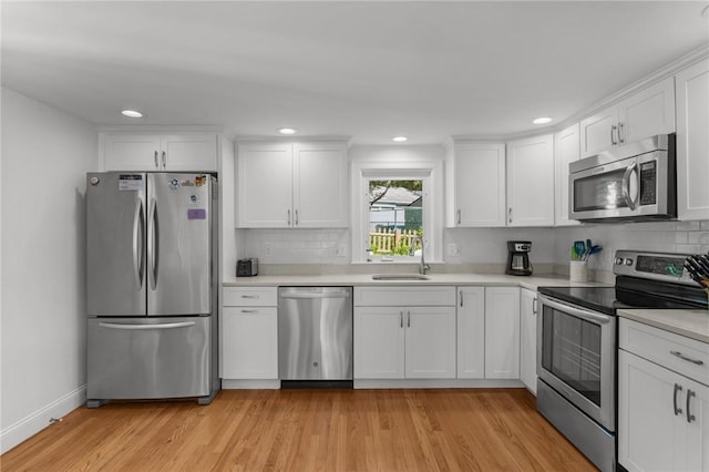 19 Woodsia Rd, Narragansett, RI 02874 - kitchen with appliances with stainless steel finishes, a sink, light countertops, white cabinetry, and light wood finished floors