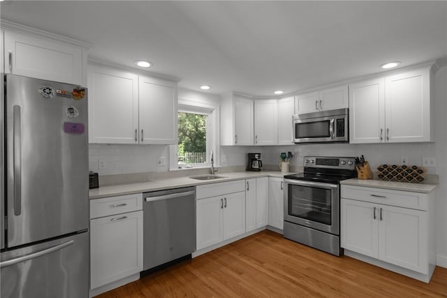 19 Woodsia Rd, Narragansett, RI 02874 - kitchen featuring stainless steel appliances, a sink, light wood-type flooring, white cabinetry, and light countertops