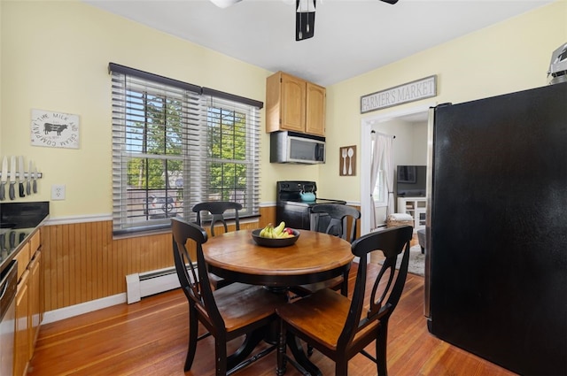 30 Lincoln St, Smithfield, RI 02917 - dining space with baseboard heating, wood finished floors, wainscoting, ceiling fan, and wooden walls