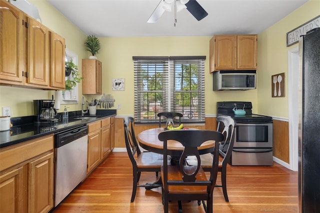 30 Lincoln St, Smithfield, RI 02917 - kitchen featuring stainless steel appliances, wainscoting, a ceiling fan, light wood-style floors, and dark countertops