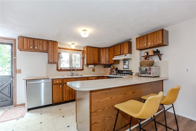 339 Beverage Hill Ave, Pawtucket, RI 02861 - kitchen with dishwasher, under cabinet range hood, a sink, brown cabinetry, and a peninsula