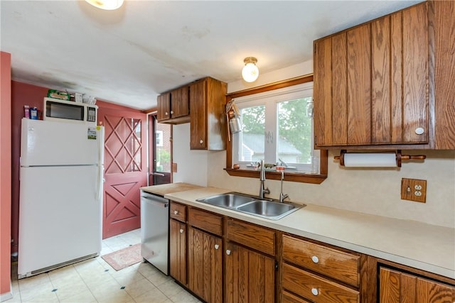 339 Beverage Hill Ave, Pawtucket, RI 02861 - kitchen with freestanding refrigerator, dishwasher, a sink, brown cabinetry, and light countertops