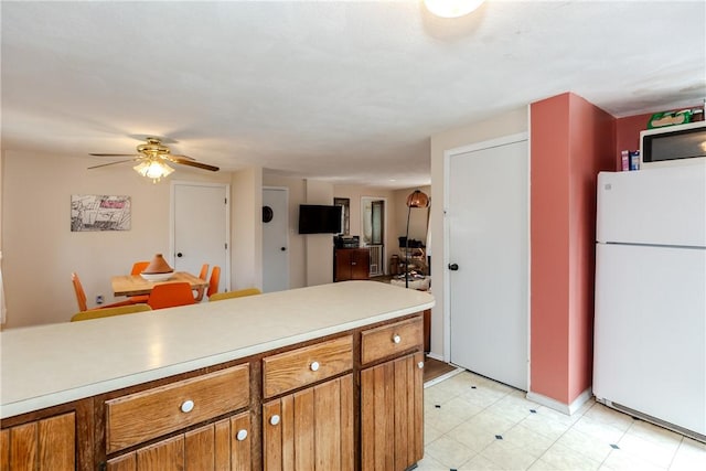 339 Beverage Hill Ave, Pawtucket, RI 02861 - kitchen with freestanding refrigerator, brown cabinets, light countertops, and ceiling fan