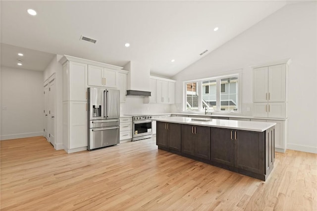 66 Orchard Ave, Johnston, RI 02919 - kitchen featuring high quality appliances, light countertops, white cabinets, light wood-style flooring, and recessed lighting