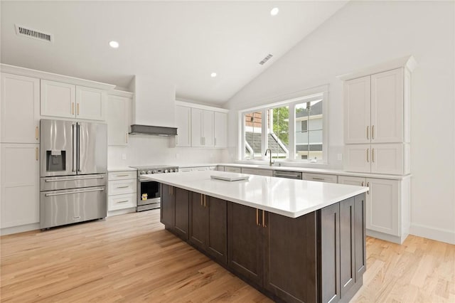 66 Orchard Ave, Johnston, RI 02919 - kitchen with stainless steel appliances, premium range hood, a kitchen island, white cabinets, and light countertops