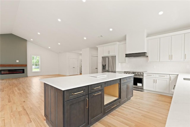 66 Orchard Ave, Johnston, RI 02919 - kitchen featuring premium appliances, white cabinetry, light wood-style floors, light countertops, and vaulted ceiling