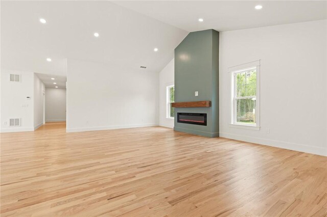 66 Orchard Ave, Johnston, RI 02919 - unfurnished living room featuring healthy amount of natural light, a glass covered fireplace, recessed lighting, light wood-style floors, and high vaulted ceiling