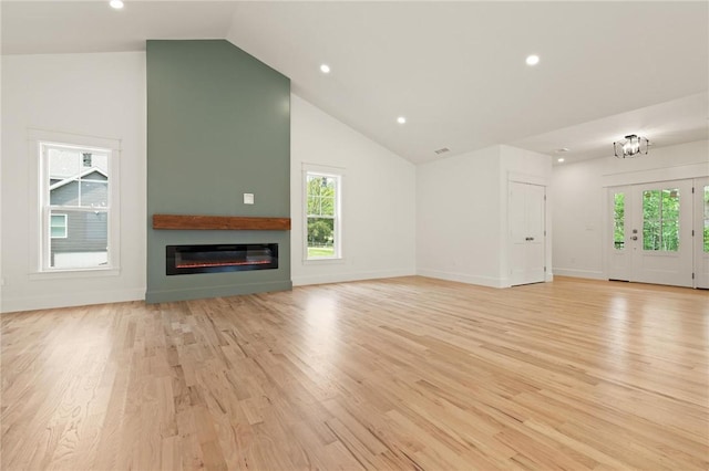 66 Orchard Ave, Johnston, RI 02919 - unfurnished living room featuring light wood-style flooring, vaulted ceiling, recessed lighting, plenty of natural light, and a glass covered fireplace