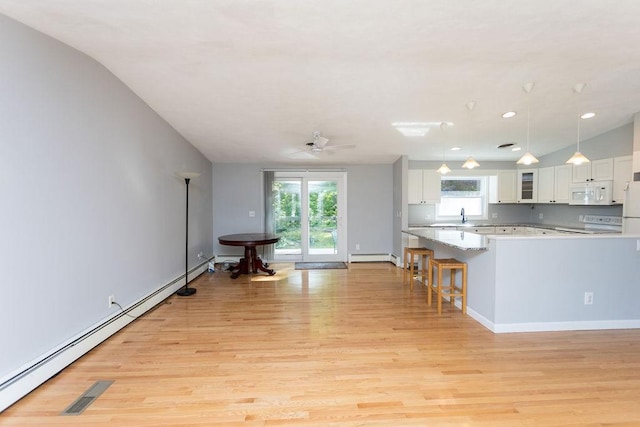 38 Williams Rd, Smithfield, RI 02917 - kitchen with white appliances, light wood finished floors, white cabinets, light countertops, and healthy amount of natural light