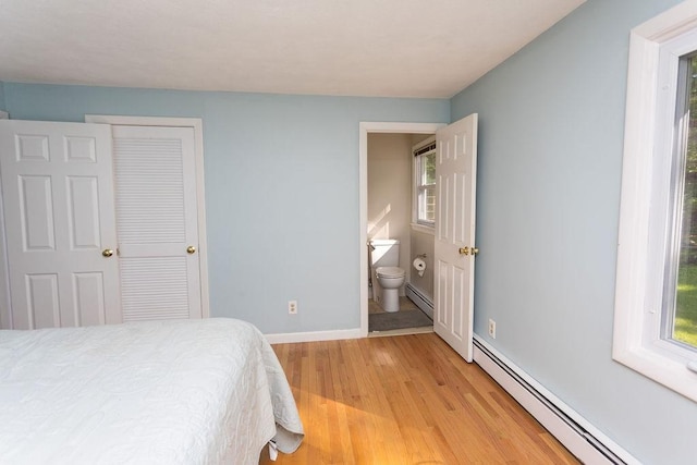 38 Williams Rd, Smithfield, RI 02917 - bedroom featuring a baseboard heating unit, light wood-style floors, baseboards, and connected bathroom
